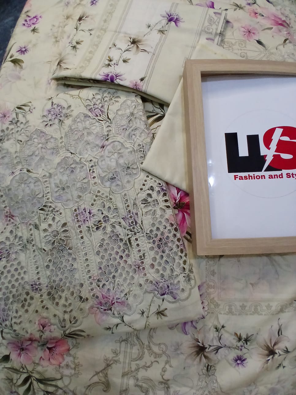Detailed close-up of embroidered front on off-white lawn shirt with pink and purple floral digital print and fine stitching