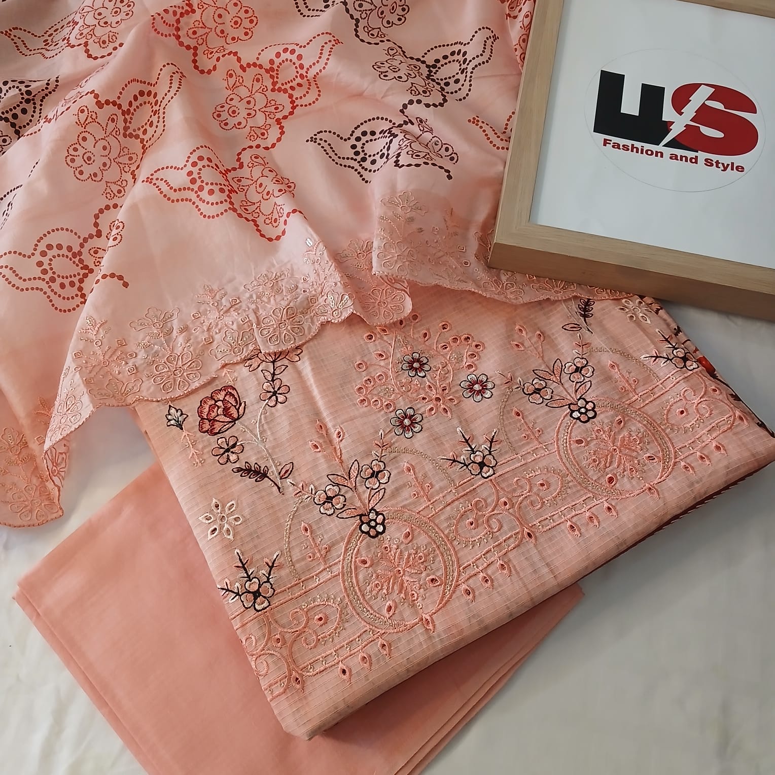 closeup detailed embroidery work on peach doria lawn shirt fabric