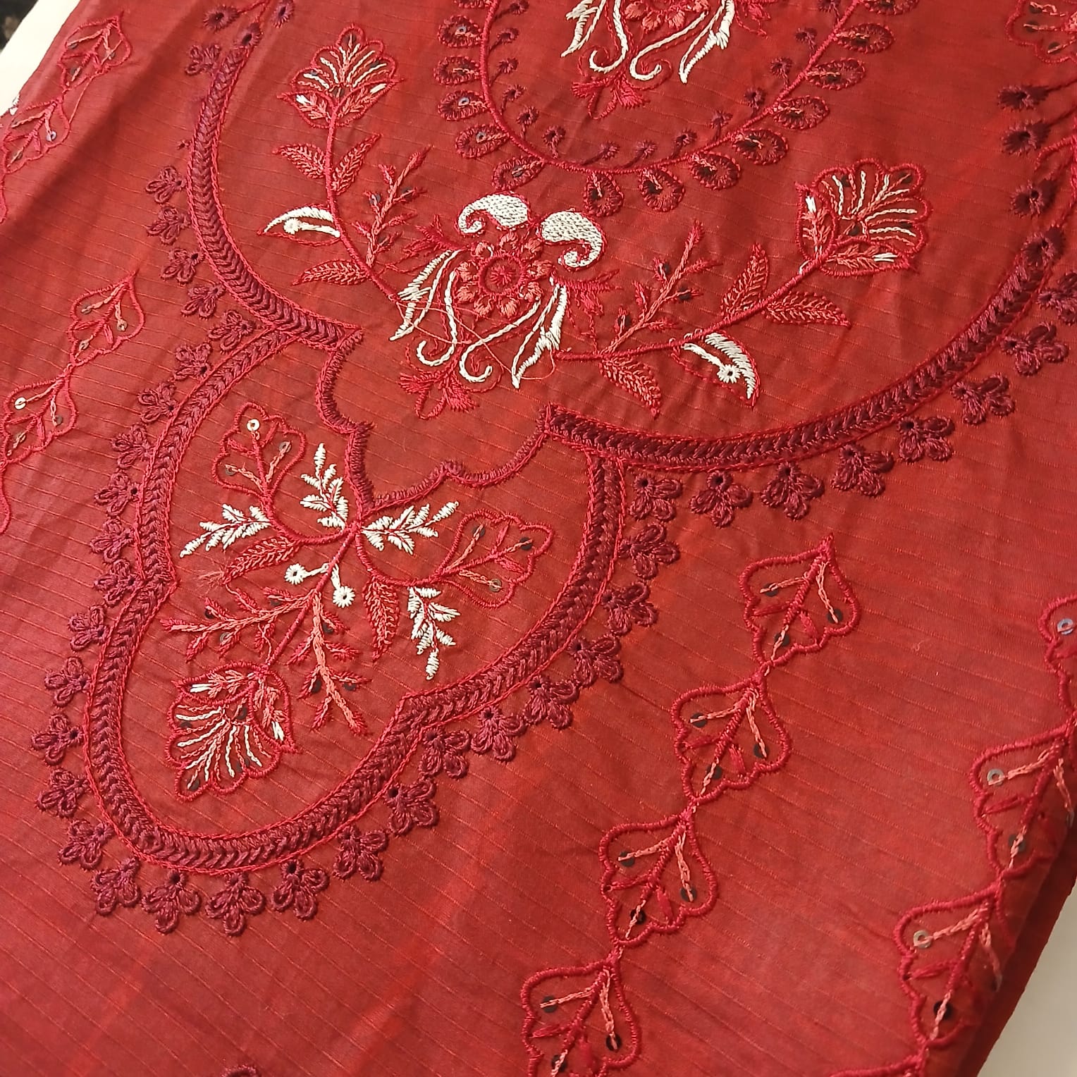 closeup heavy embroidery on red doria lawn shirt fabric